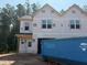 New two-story home showcasing its facade with large windows and attached garage, during construction at 15 Calluna Dr, Clayton, NC 27520