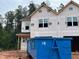 New construction featuring a modern exterior design with large windows, creating an inviting curb appeal in a wooded setting at 15 Calluna Dr, Clayton, NC 27520