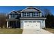 Beautiful two-story home with blue siding, stone accents, and a spacious two-car garage at 1667 Pecan Drive # 25, Nashville, NC 27856