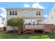 Two-story home showcasing a wood deck, lush green grass, and mature trees, creating a serene outdoor living space at 1910 Morehead Hill Ct, Durham, NC 27703