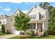 Charming two-story home with a well-manicured lawn, mature tree, and inviting front porch at 1910 Morehead Hill Ct, Durham, NC 27703