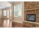 Living room featuring a stone fireplace, hardwood floors, and large windows at 1910 Morehead Hill Ct, Durham, NC 27703