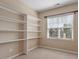 This walk-in closet features white shelving and a window for ventilation and natural light at 1910 Morehead Hill Ct, Durham, NC 27703