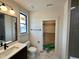 Modern bathroom with gray tile, single vanity, and open closet at 200 Broadleaf Ln, Louisburg, NC 27549