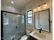 Bathroom featuring tiled shower with glass doors, a modern vanity, and a black framed mirror at 200 Broadleaf Ln, Louisburg, NC 27549