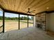 Spacious covered patio with a stone fireplace and ceiling fan overlooking the large yard at 200 Broadleaf Ln, Louisburg, NC 27549
