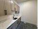 Laundry room with gray cabinets, quartz countertop, and modern black hardware at 200 Broadleaf Ln, Louisburg, NC 27549