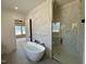 Elegant main bathroom with a freestanding tub and a separate shower with stunning marble-look tile at 200 Broadleaf Ln, Louisburg, NC 27549