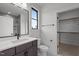 Modern bathroom with a dark vanity, large mirror, and a closet with shelves at 200 Broadleaf Ln, Youngsville, NC 27596