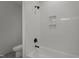 Bright bathroom featuring white tile, dark fixtures, and built-in shelving at 200 Broadleaf Ln, Youngsville, NC 27596