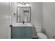 This bathroom features blue cabinets and a white countertop with black hardware and lighting at 200 Broadleaf Ln, Youngsville, NC 27596