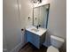 Bathroom features a modern vanity, toilet, and fixtures with a black framed mirror at 200 Broadleaf Ln, Youngsville, NC 27596