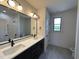 Bathroom featuring a double sink vanity with black hardware and neutral paint and floors at 200 Broadleaf Ln, Youngsville, NC 27596