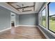 This bedroom features tray ceilings, hardwood floors, and beautiful outdoor views at 200 Broadleaf Ln, Youngsville, NC 27596