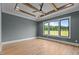 This spacious bedroom features tray ceilings, hardwood floors, and a large window at 200 Broadleaf Ln, Youngsville, NC 27596