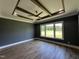 Bedroom with a modern ceiling fan, wood floors, and a large window with backyard views at 200 Broadleaf Ln, Youngsville, NC 27596