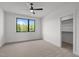 This bedroom offers a walk-in closet, carpet flooring, a ceiling fan and a window at 200 Broadleaf Ln, Youngsville, NC 27596