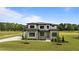 Exterior of home featuring stone accents, manicured lawn, and mature trees at 200 Broadleaf Ln, Youngsville, NC 27596