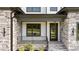 Inviting front porch with stone accents and a modern, sleek door at 200 Broadleaf Ln, Youngsville, NC 27596