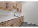 Laundry room with updated cabinets, granite countertops and a black faucet at 200 Broadleaf Ln, Youngsville, NC 27596