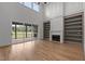 Bright living room featuring hardwood floors, fireplace, bookshelves, and large windows at 200 Broadleaf Ln, Youngsville, NC 27596