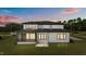 Exterior rear of house shows patio, siding, and multiple windows at dusk at 200 Broadleaf Ln, Youngsville, NC 27596