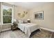 Comfortable bedroom with neutral tones, a patterned rug, and ample natural light from the window at 203 Great Smoky Pl, Lillington, NC 27546