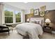 Comfortable bedroom with large windows overlooking trees and stylish decor at 203 Great Smoky Pl, Lillington, NC 27546