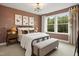 Charming bedroom featuring framed art wall, large window, and wrought iron bed frame at 203 Great Smoky Pl, Lillington, NC 27546