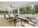 Covered patio with ceiling fans, outdoor seating, and views of a wooded area at 203 Great Smoky Pl, Lillington, NC 27546