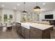 Bright kitchen features a farmhouse sink, stainless steel appliances, and an island with bar seating at 203 Great Smoky Pl, Lillington, NC 27546