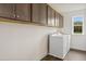 Functional laundry room featuring ample upper cabinet space and modern washing machines at 203 Great Smoky Pl, Lillington, NC 27546