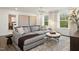 Open-concept living room with a comfortable sectional sofa, natural lighting, and stylish decor at 203 Great Smoky Pl, Lillington, NC 27546