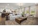 Cozy living room showcasing a large sofa, decorative rug, and abundant natural light at 203 Great Smoky Pl, Lillington, NC 27546