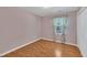 Bedroom with floral curtains, a window, wood floors, and a closet at 205 Lizzie King Ct, Willow Springs, NC 27592