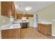 Open concept kitchen with neutral walls, wood cabinets, white countertops, and modern appliances, including a dishwasher and oven at 205 Lizzie King Ct, Willow Springs, NC 27592