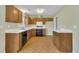 Well-lit kitchen with wood cabinets, white countertops, and modern appliances, including a dishwasher and oven at 205 Lizzie King Ct, Willow Springs, NC 27592