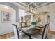 Dining room with statement light fixture, wainscoting, and arched doorway to living spaces at 211 Page St, Morrisville, NC 27560