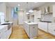 Bright kitchen features white cabinets, stainless appliances, wooden floors and pendant lighting at 211 Page St, Morrisville, NC 27560