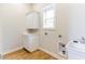 Laundry room with white cabinets, sink, and hardwood floors. Washer/dryer hookups available at 211 Page St, Morrisville, NC 27560