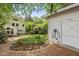This backyard showcases a lovely garden area, quaint brick pathway, and a convenient detached garage at 223 Hawthorne Rd, Raleigh, NC 27605