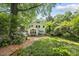 A stone patio and lush landscaping offer a private retreat in the backyard of this charming two-story home at 223 Hawthorne Rd, Raleigh, NC 27605
