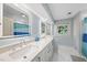 Bright bathroom with double sinks, a window, and a shower with a colorful curtain at 223 Hawthorne Rd, Raleigh, NC 27605