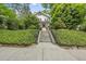 Charming home featuring meticulously kept landscaping with a inviting staircase leading up to the front door at 223 Hawthorne Rd, Raleigh, NC 27605