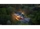 Aerial of a large brick home with a manicured lawn, wooded perimeter, and a long driveway at twilight at 2238 Lakeview Ter, Burlington, NC 27215