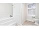All-white bathroom with large soaking tub, shower with curtain and neutral tile at 2238 Lakeview Ter, Burlington, NC 27215