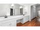 Bathroom with double sinks, vanity, large mirrors and wood flooring at 2238 Lakeview Ter, Burlington, NC 27215