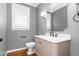 Bathroom featuring gray walls, decorative mirror, modern fixtures, white marble countertop and light beige cabinetry at 2238 Lakeview Ter, Burlington, NC 27215
