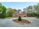 Spacious brick home with a circular driveway, manicured flowerbeds, and a three-car attached garage at 2238 Lakeview Ter, Burlington, NC 27215