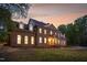 Side view of a grand brick home with arched windows, dormers, and a covered entrance on a landscaped lot at 2238 Lakeview Ter, Burlington, NC 27215